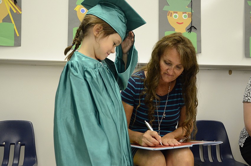 Carrie Sarkissian gets Christina Mohr, the teacher's aide for the preschool class, to sign her book.