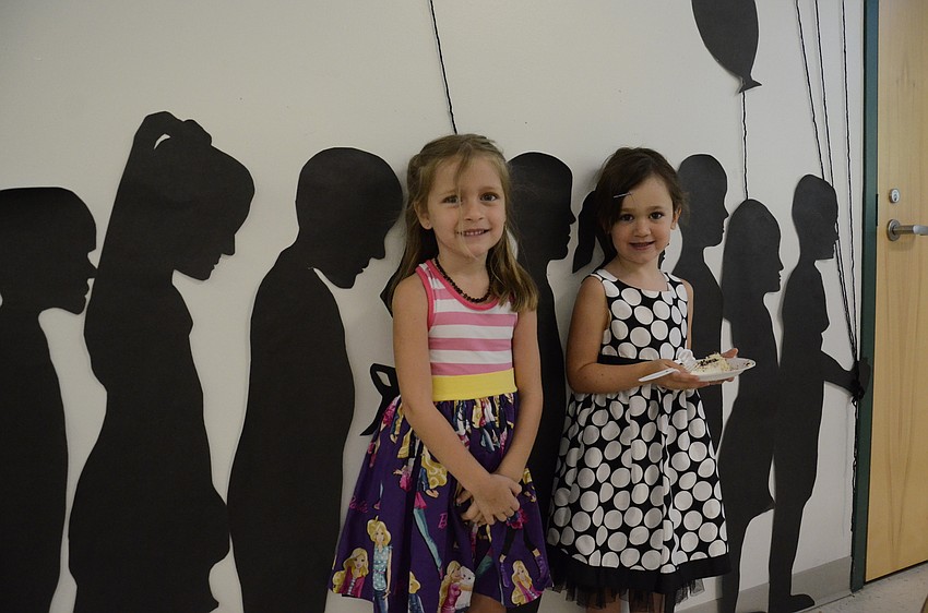 Taryn Factor and Carrie Sarkissian stand beside the silhouettes they made in class.