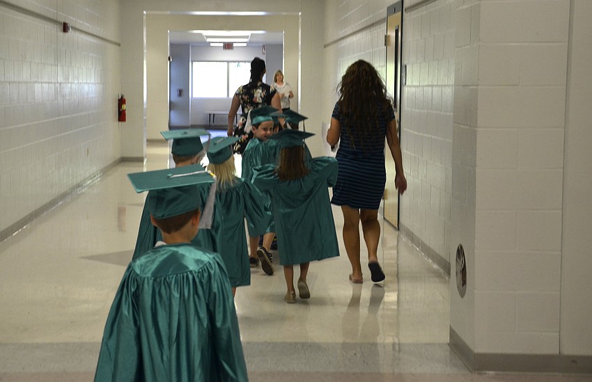 Christina Mohr leads the graduates into the classroom for the ceremony.