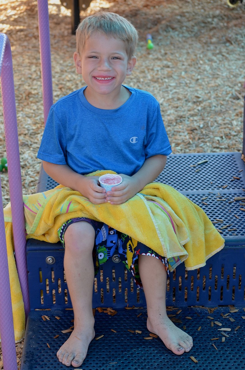 Jared Gyure dries off on the playground after playing in the pool.