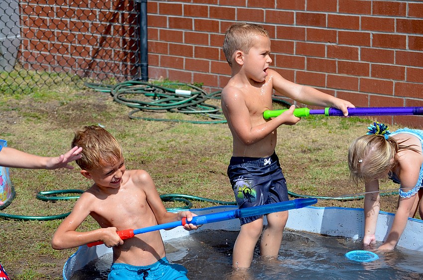 Ivo Kratuntravkio and Caden McClusku launch a water attack on their nearby friends.