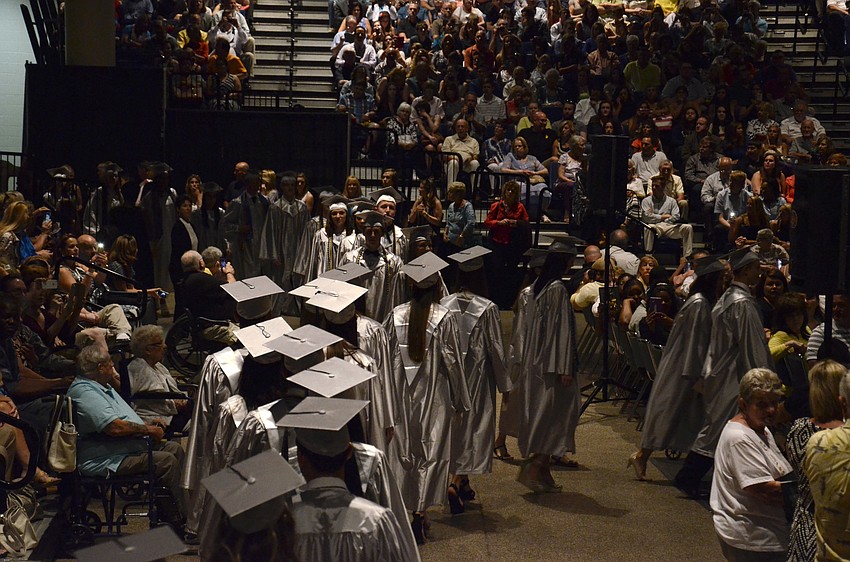 The top ten percent of the class, who wore silver robes, walk to their seats.