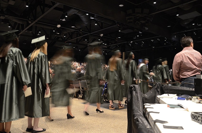 Students walk to their seats in the convention center.