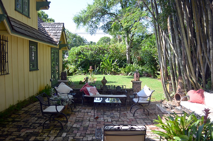 The back yard has been designed as several garden rooms, including a brick-terraced seating area, an enclosed rose garden, a tiny rectangular pond and a grove of bamboo that soars four stories high.