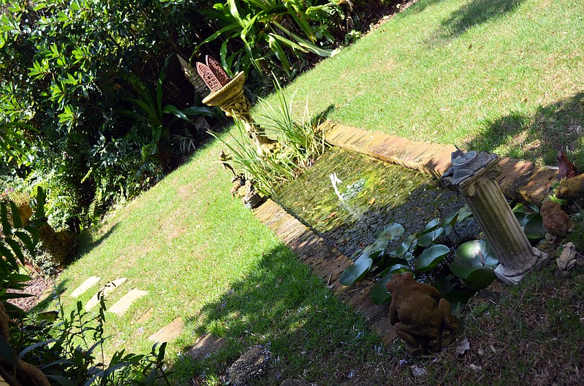 The back yard has been designed as several garden rooms, including a brick-terraced seating area, an enclosed rose garden, a tiny rectangular pond and a grove of bamboo that soars four stories high.