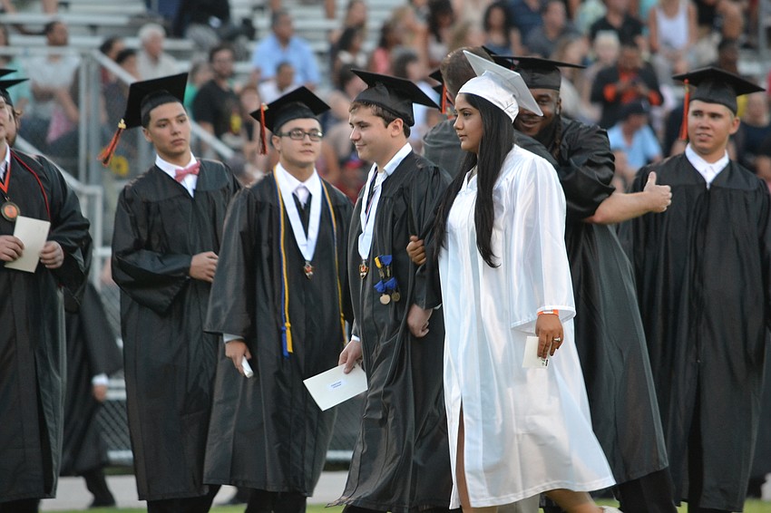Students make their way on the field to start the commencement ceremony.