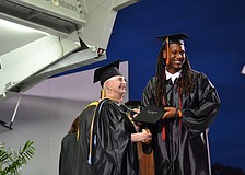 Warren Anderson receives his diploma from Sarasota County School Board Member Caroline Zucker.