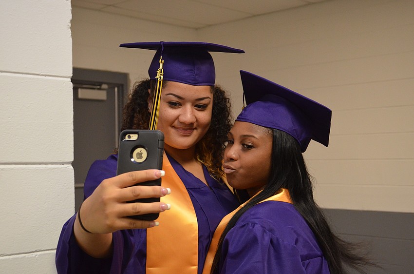Brandi Thibodeau and Tyra Walker sneak in a selfie before walking out with classmates.