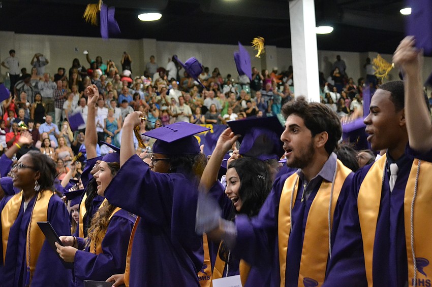 Graduates toss their caps to celebrate.