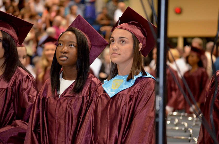 Jenny Chevalier and Kristen Colonna watch their senior video before receiving their diplomas.