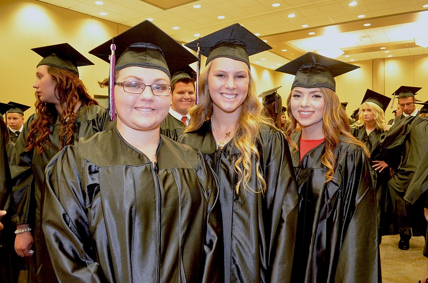 Olha Chyshkevych, Kendra Clark and Tatum Clark show off matching graduation gear and smiles.