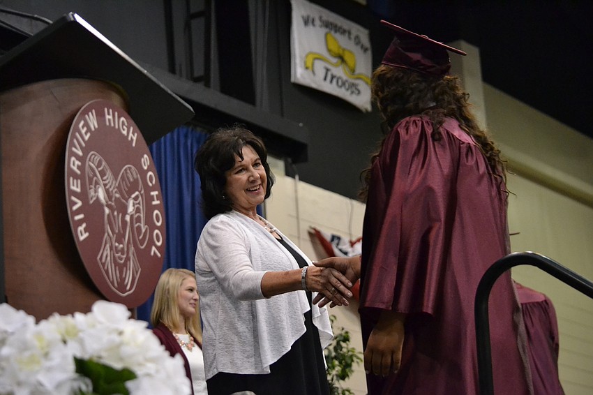 Alejandra Flores and Riverview High School Principal Linda Nook shake hands.