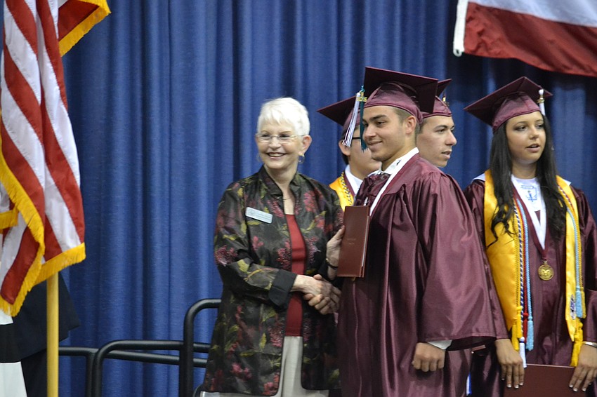 Alex Darby receives his diploma from Sarasota County School Board Member Caroline Zucker.