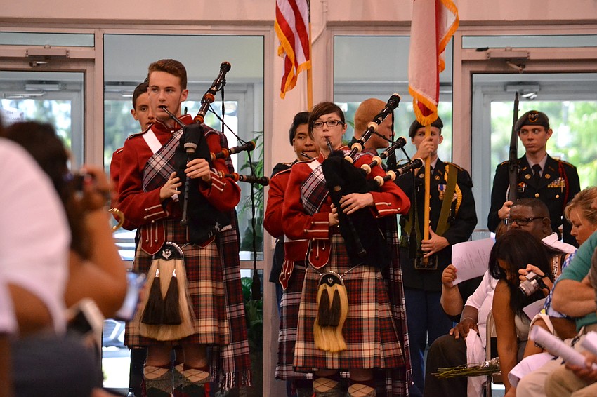 Members of the Riverview High School Kiltie Pipes band play during the presentation of colors.