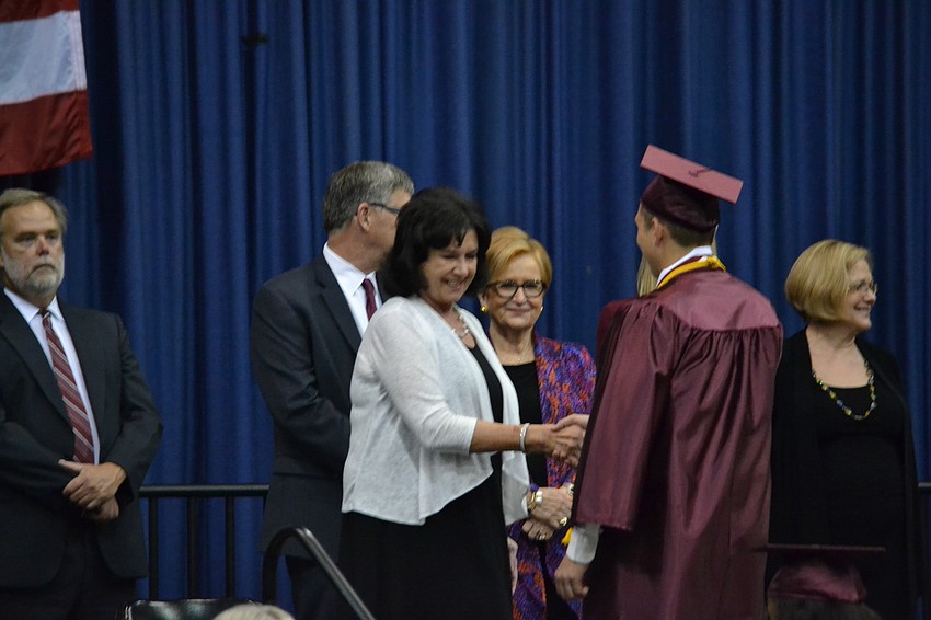 Vincent Dazio and Principal Linda Nook shake hands.