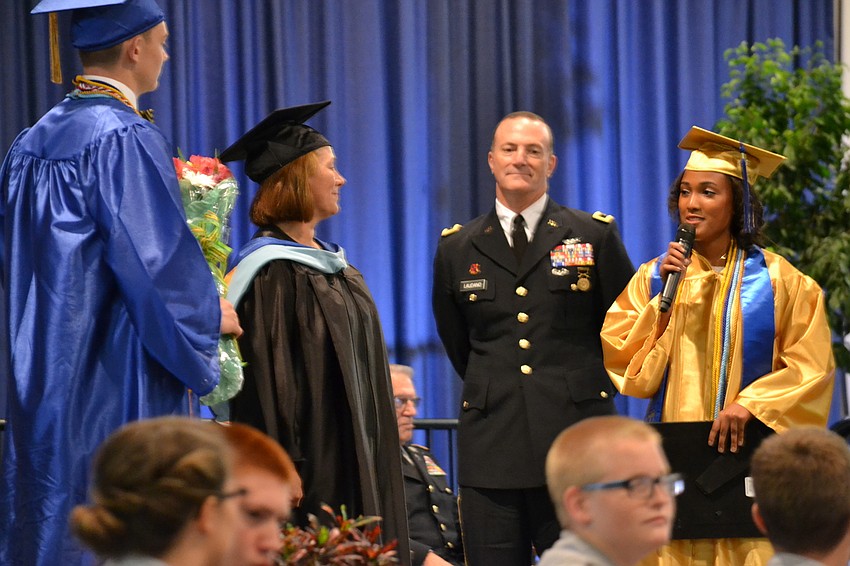 Christina Bowman receives a bouquet and plaque from graduating Cadet Regimental Commander Whitney Stewart.