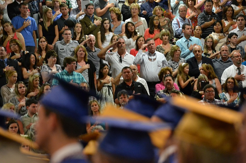 Students stand for the national anthem. 
053015-SMAGraduation-Parents-Parents stand for the national anthem.