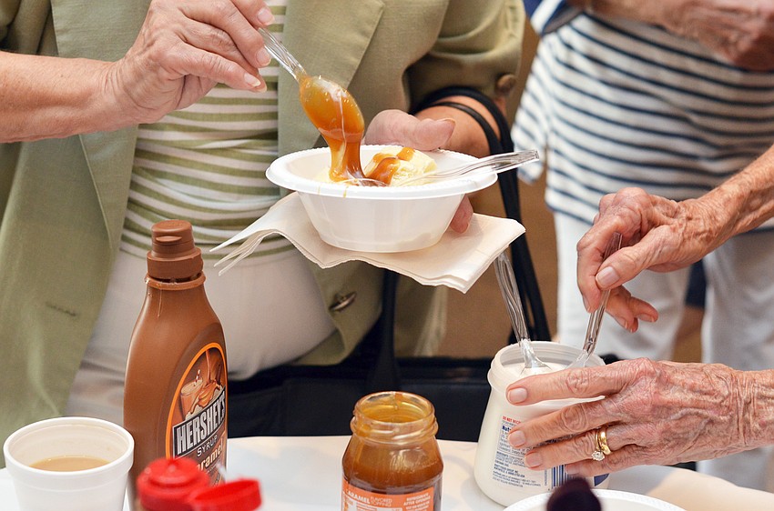 Guests at the St. Boniface Ice Cream Social add toppings to their ice cream.