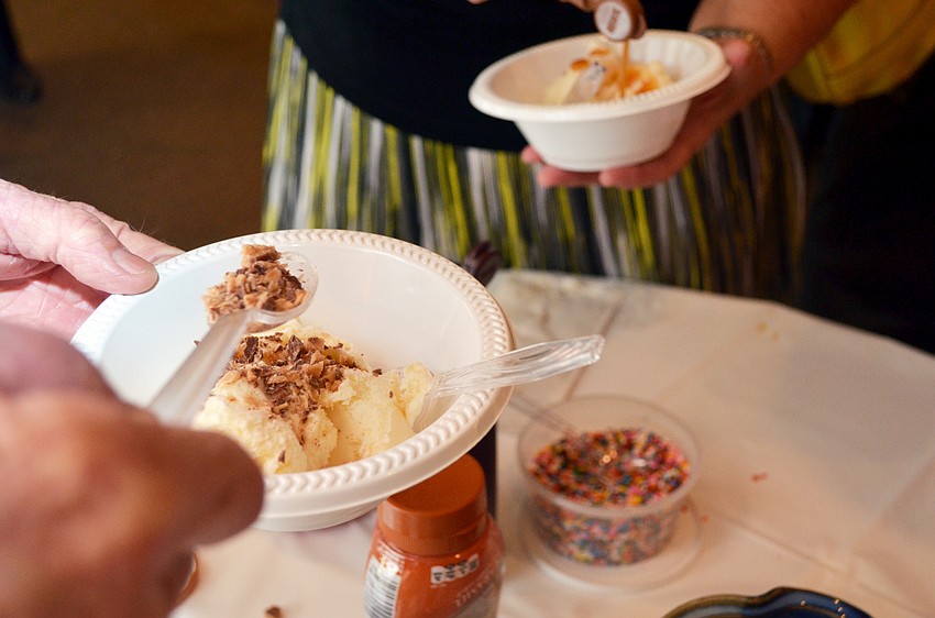 Guests at the St. Boniface Ice Cream Social add toppings to their ice cream