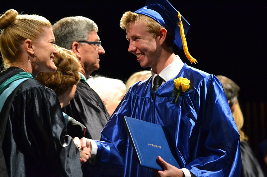 Pine View School Assistant Principal Jennifer Nzeza congratulates Ian Asselstine.