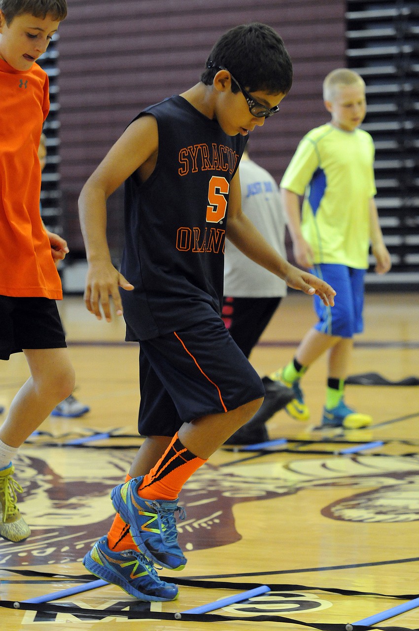 Nine-year-old Travis Smith works on improving his footwork with the aid of a ladder.