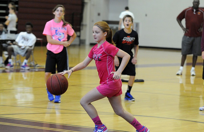 Eleven-year-old Madeline Boehm drives to the lane during Riverview High’s basketball camp June 3.