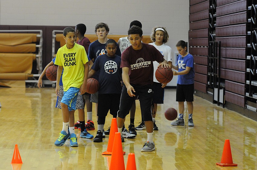 Riverview High point guard D.J. Bryant works with campers on their ball handling skills.