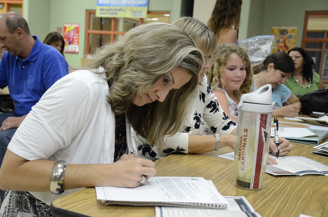 Susan Myers, a McNeal parent, writes down notes about each candidate.