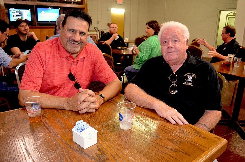 Tony Cipriano and James Duncan enjoy cold drinks before the poker rounds begin.