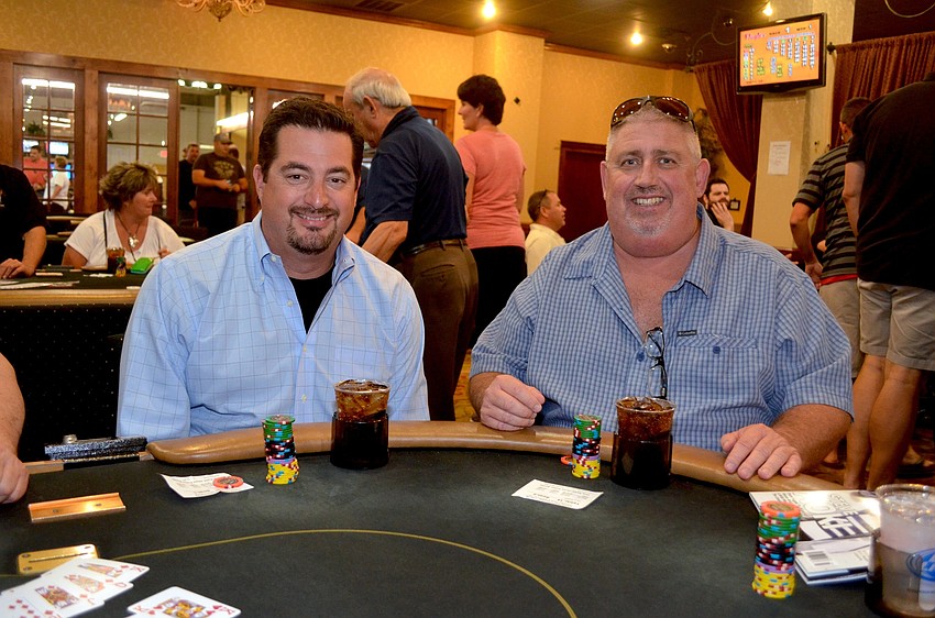 Chris Tomasso and David Magee find their seats at a poker table.