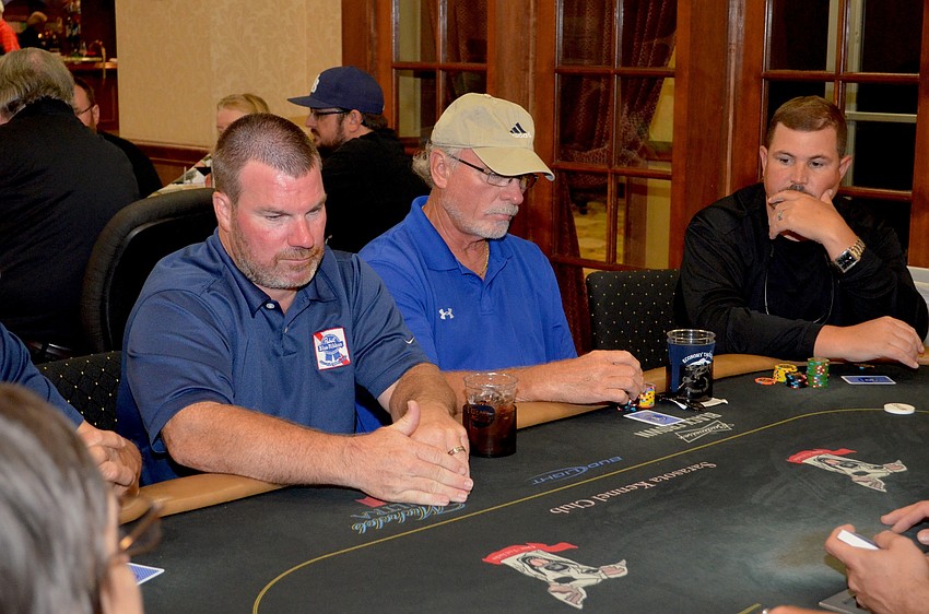 Eric Winkler secretly eyes his hand beside his opponents.