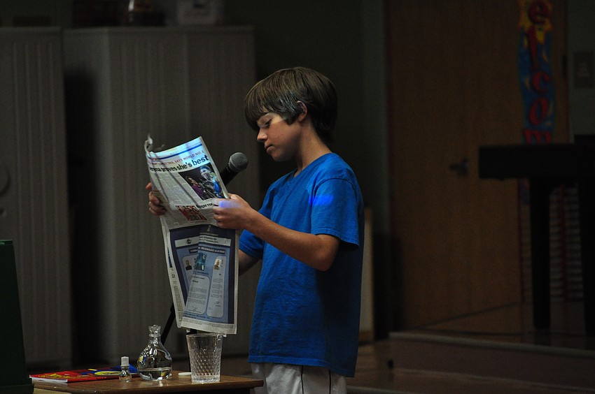 Stefan Pearl wows the audience with magic tricks, including filling this newspaper with water and emptying it.
