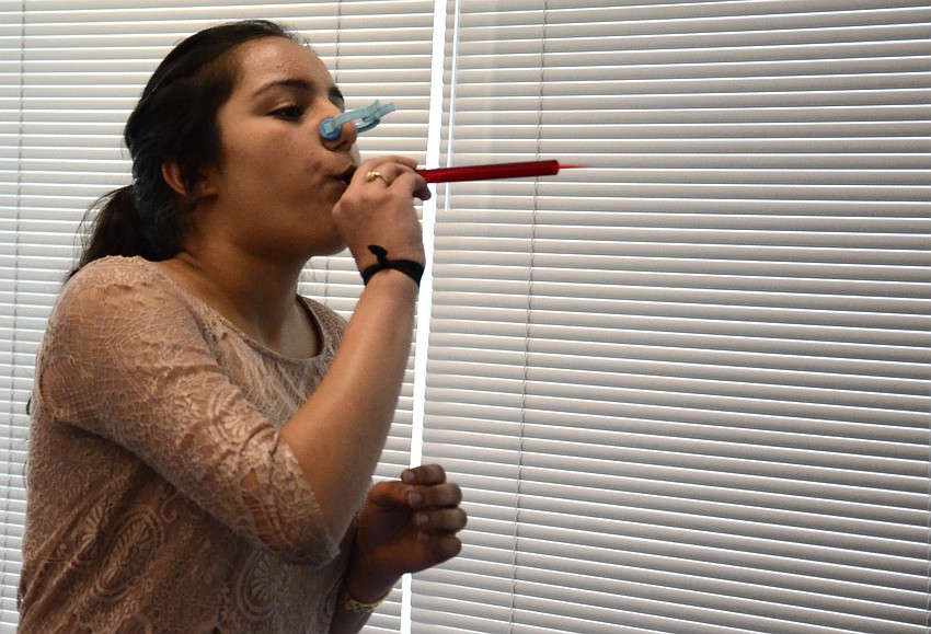 Anjali Sharma, a Pine View School junior, tests her lung strength.