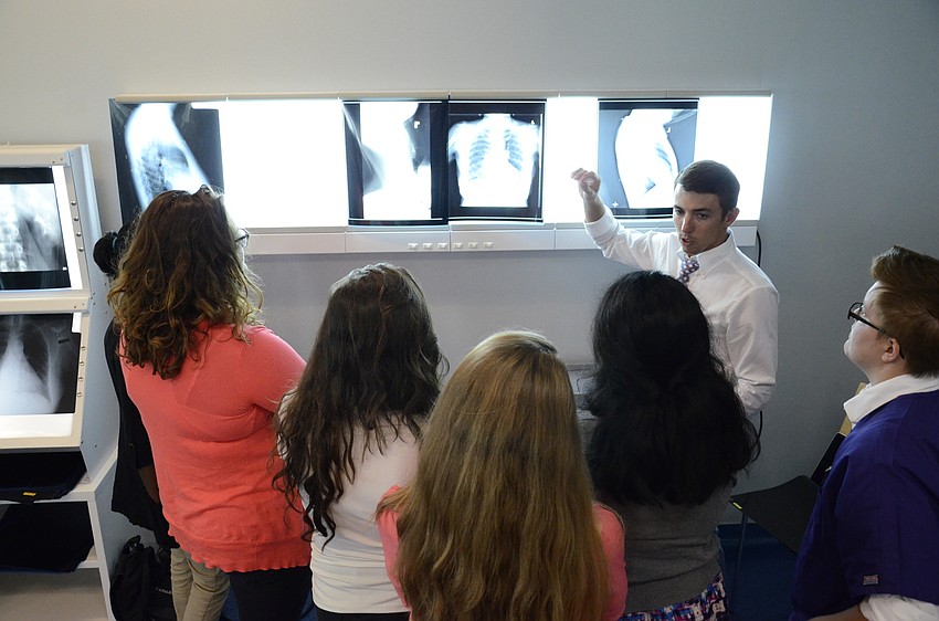 Jacob Howard, a LECOM student, explains some x-rays to high school participants.