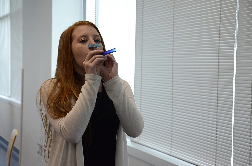 Samantha Gallahan, Pine View School junior, tests her lung skills to see how far she can shoot a stick through a straw.