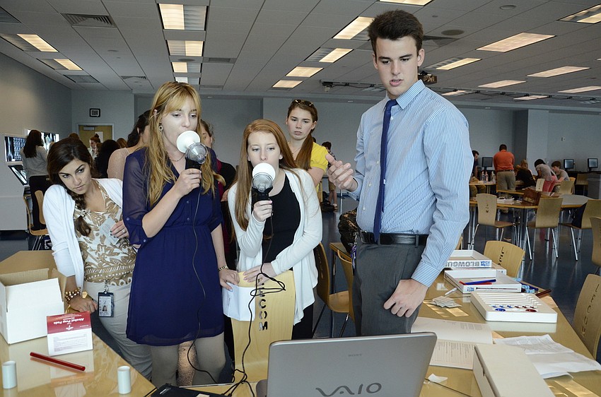 Tea Binder and Samantha Gallahan, Pine View School juniors, measure their breathing with the help of Josh Johnson, a LECOM student.