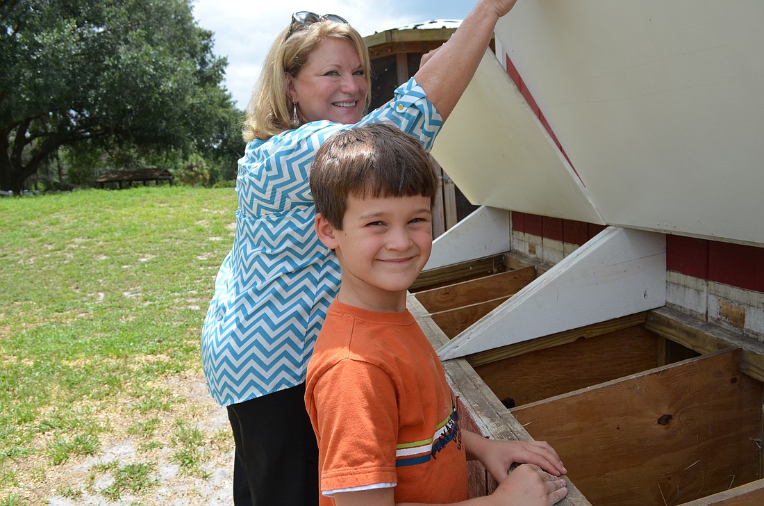 Amanda MoralesPamela Swain and her grandson Alex Popovich collect eggs from the farmâ€™s chicken coop.