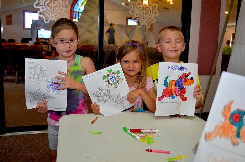 Courtney Springfield, Julia Mulligan and Logan Pope show off their artwork.