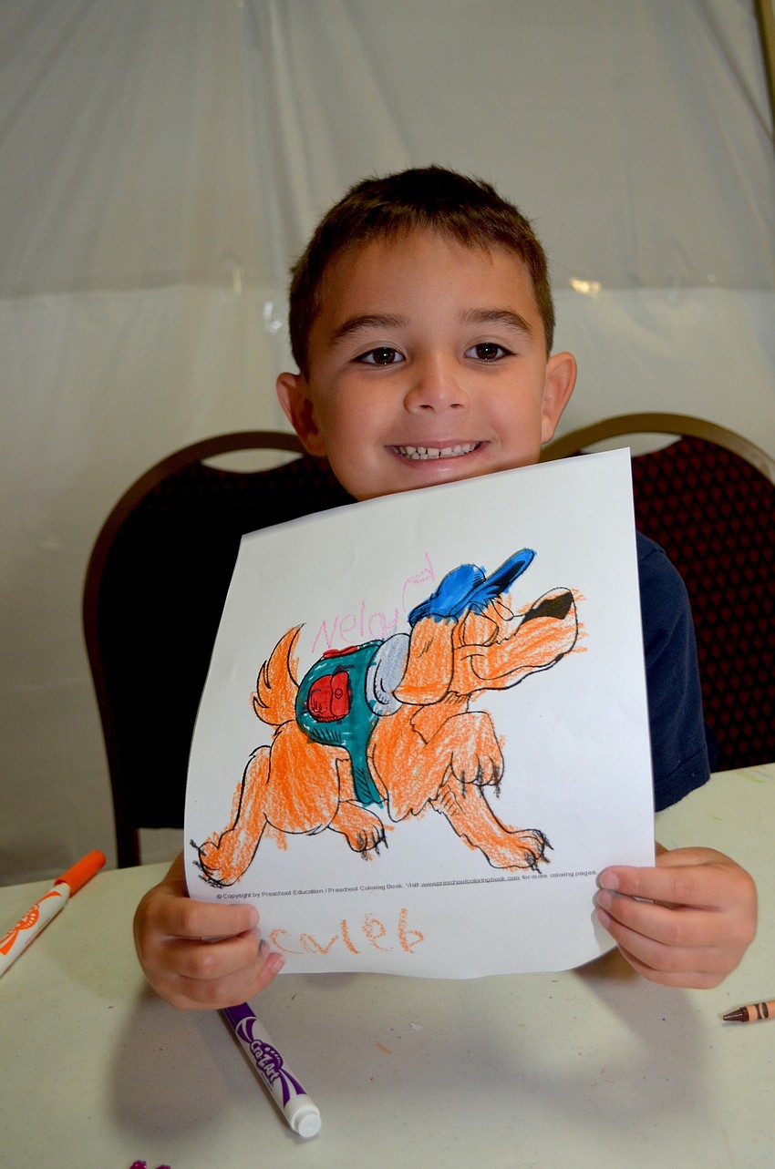 Caleb Cuevas displays a dog he colored during craft time.