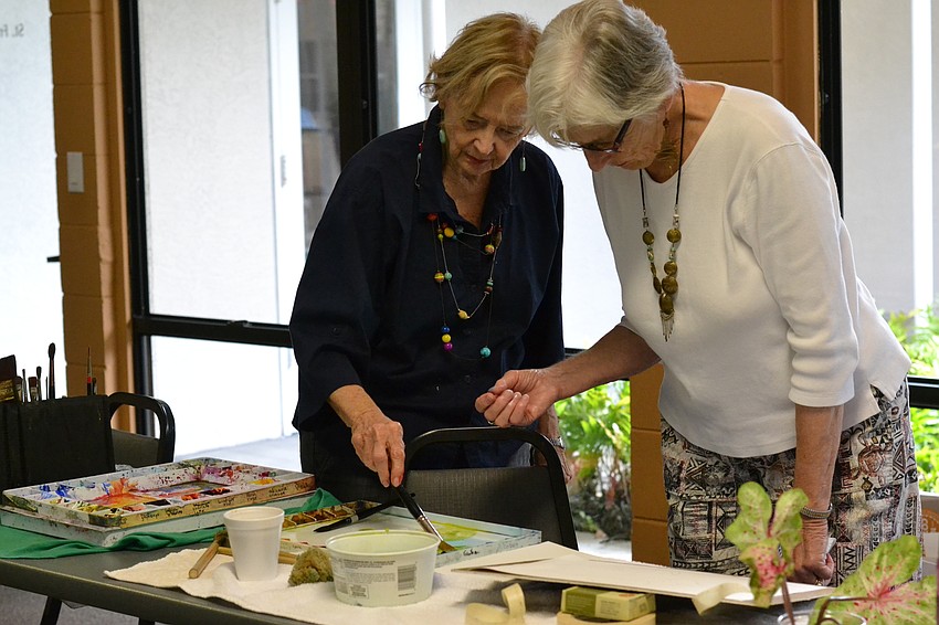 Penny Hendry and Mary Gurley work together on a painting.