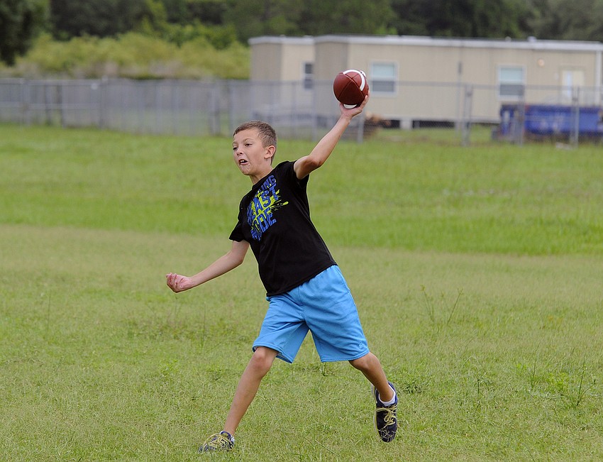 McNeal Elementary rising fifth-grader Declan Connolly drops back for a pass during Lakewood Ranch High’s football camp June 11.