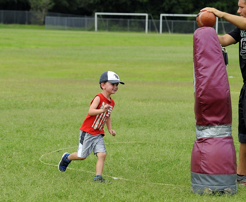 Four-year-old Cooper Mulder shows off his defensive skills during a tackling drill.