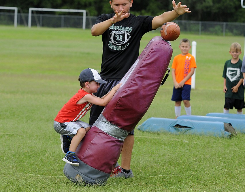 Four-year-old Cooper Mulder shows off his defensive skills during a tackling drill.