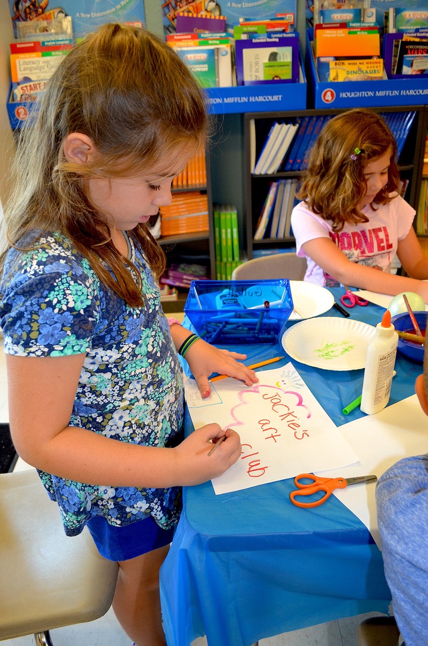 Mia Romano paints a pink cloud before taking a Popsicle break.