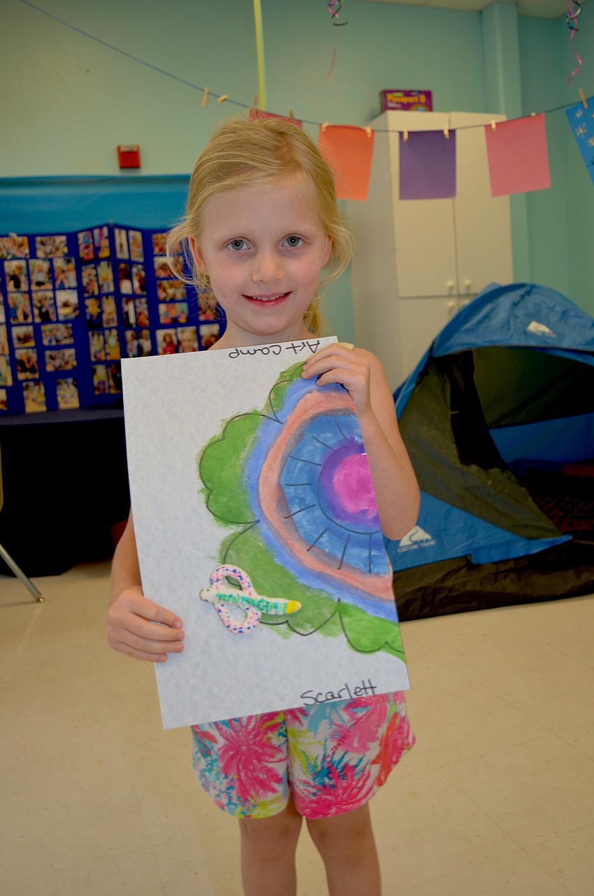 Scarlett Milbank shows off the butterfly and flower she crafted during camp.