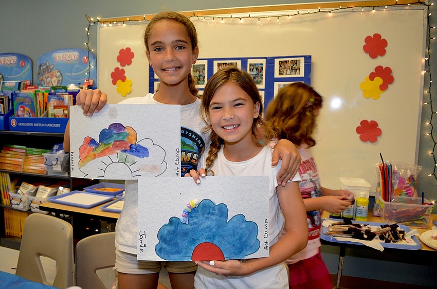 Natalia Madird and Jamie Bolduc show off their paintings.