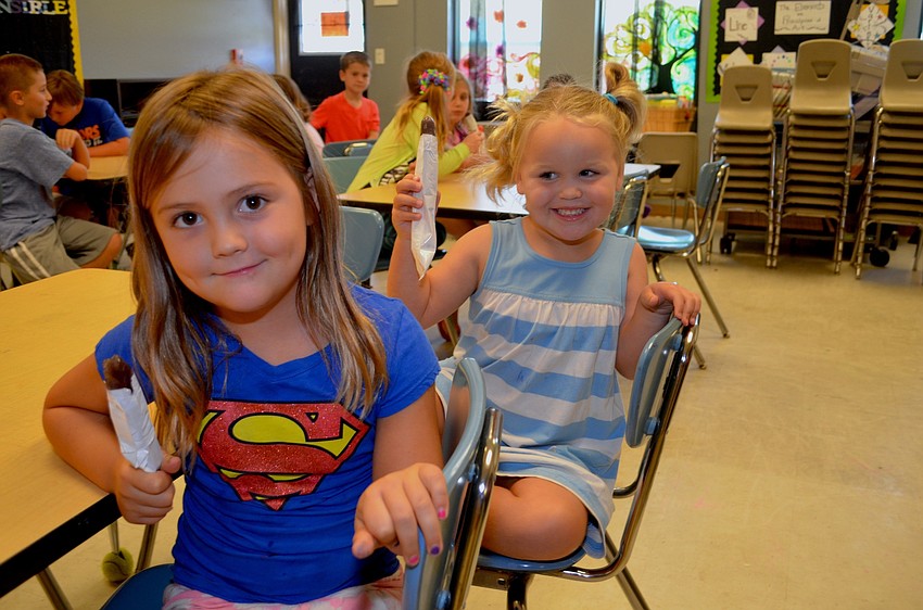 Eshun Burge and Savannah Jones enjoy cold treats while waiting for their parents to pick them up.