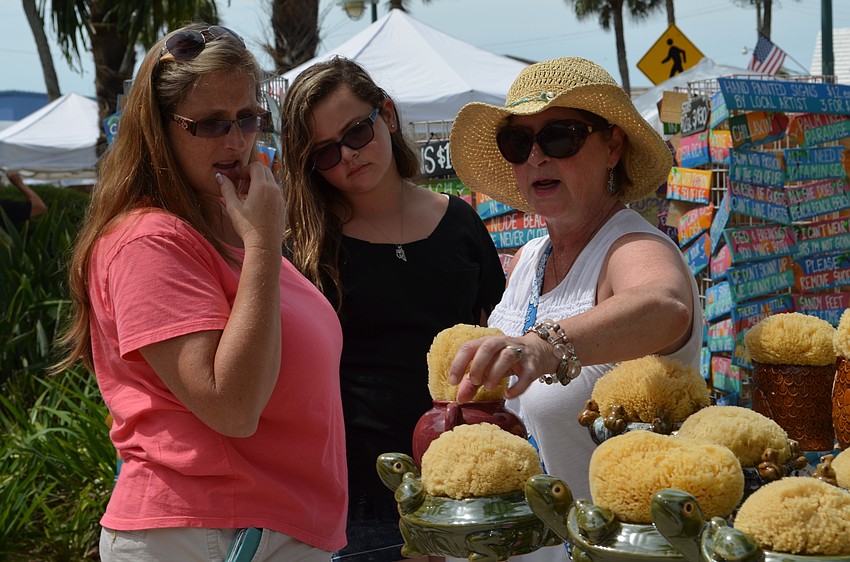 Marietta Vorholt explains how a butterfly feeder works to Cindy and Hailee Silva.