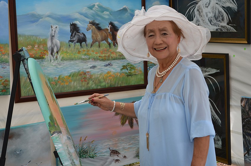 Kyung Ai Park works on a painting during the craft festival.