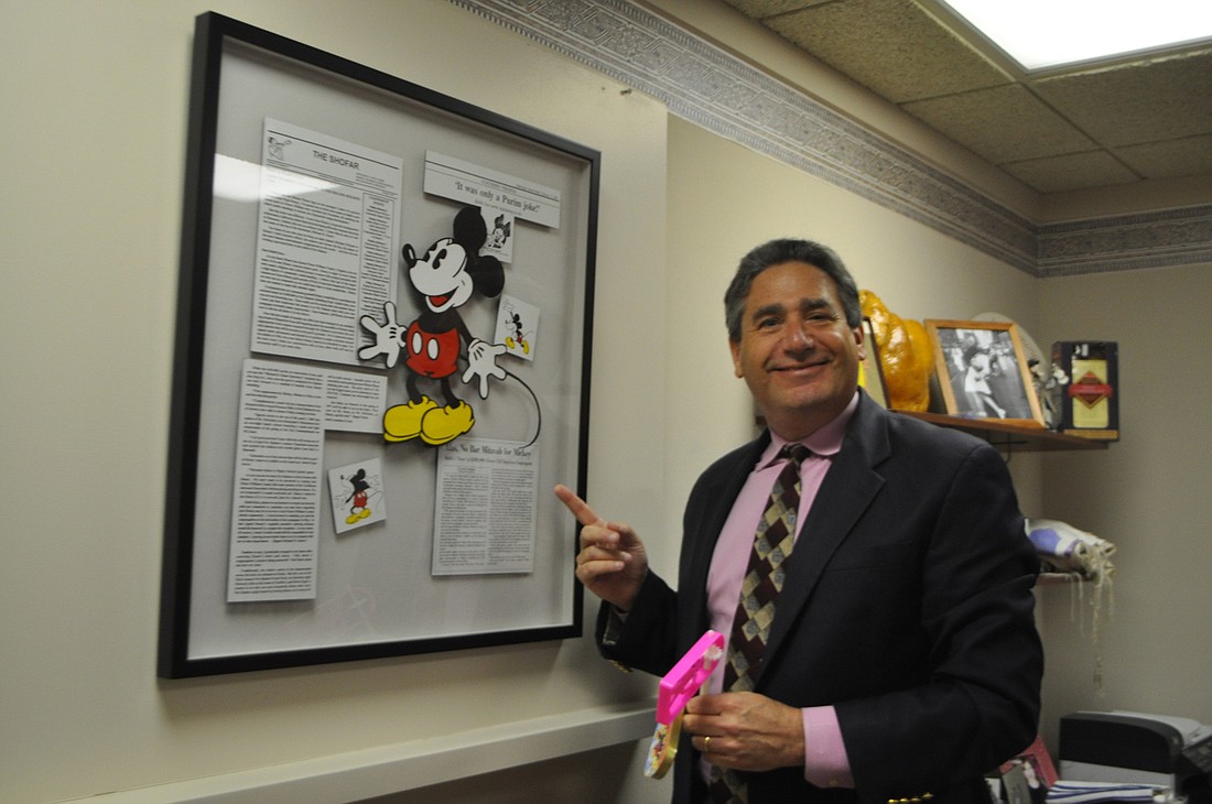 Robin Hartill Temple Beth Israel Rabbi Jonathan Katz points to news stories about his infamous 1994 Disney-themed Purimspiel that included Mickey Mouse appearances at bar mitzvahs.